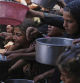 Palestinians struggle to get donated food at a community kitchen in Khan Younis, southern Gaza Strip, Friday, Sept. 19, 2025. (AP Photo/Jehad Alshrafi)