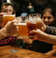 Un grupo de amigos brinda con cerveza en un bar