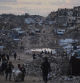 Palestinians walk past destroyed buildings in the northern Gaza Strip, Friday, Jan. 2, 2026. (AP Photo/Jehad Alshrafi)