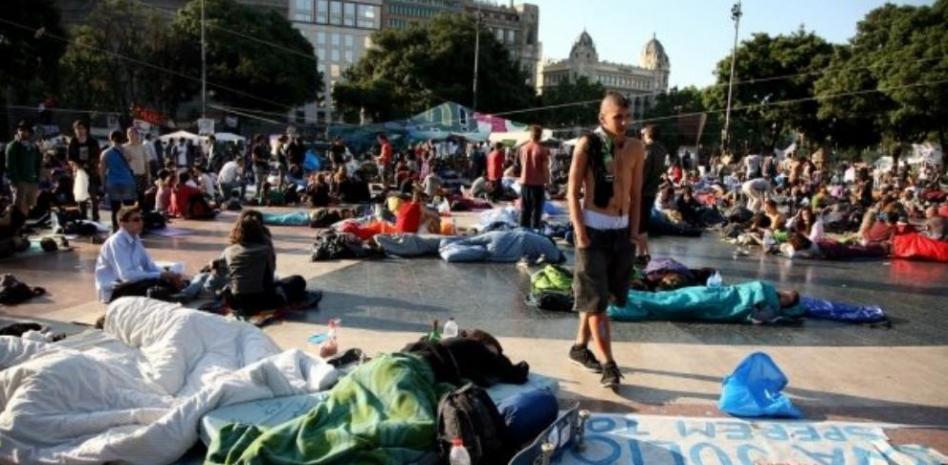 Familias, turistas y curiosos visitan a los 'indignados' de la plaza Catalunya