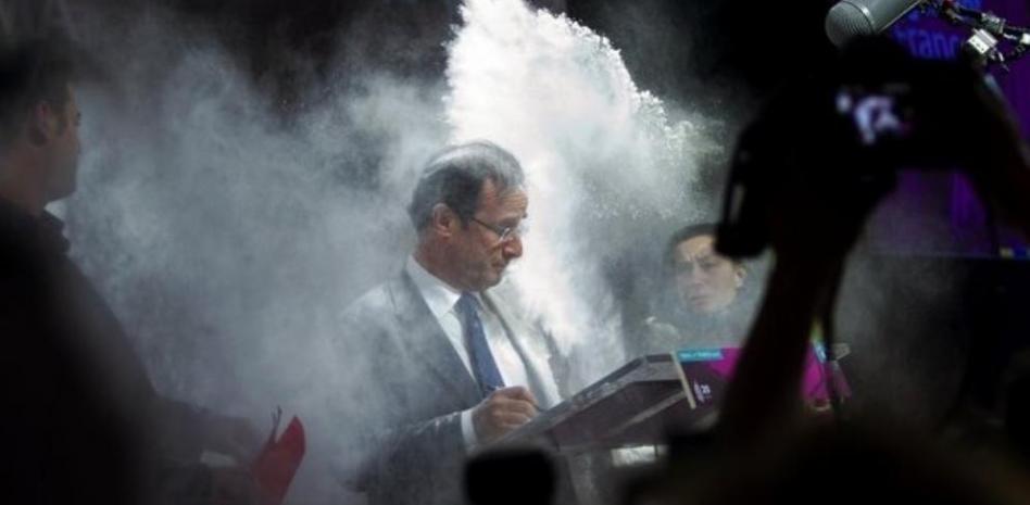 Una espontánea embadurna de harina al socialista Hollande en un acto público