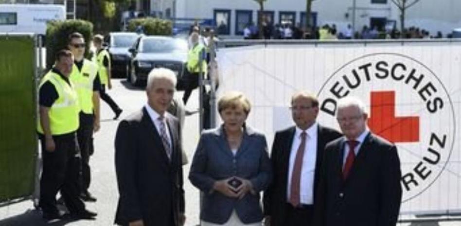 Merkel, abucheada por vecinos al visitar un centro de refugiados atacado