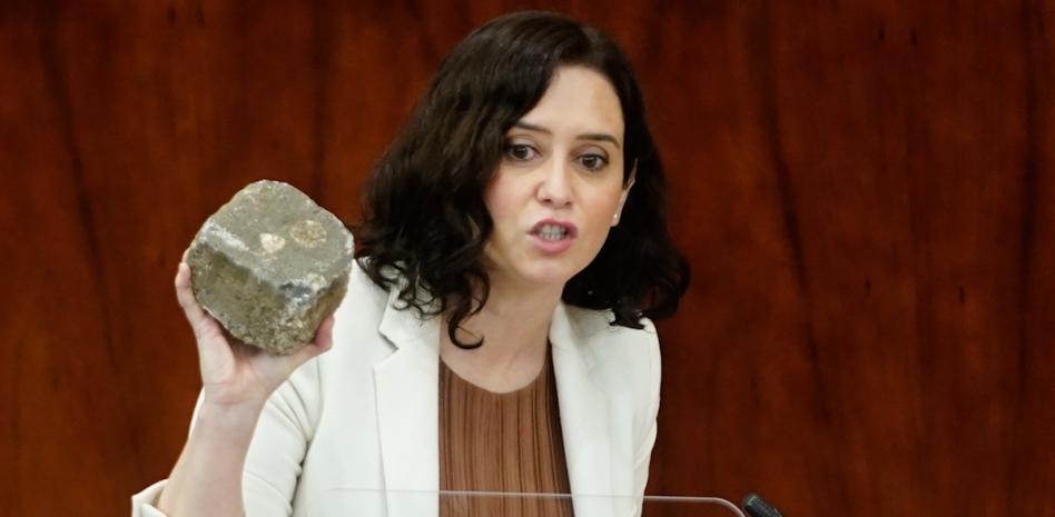 Ayuso lleva a la Asamblea un trozo de adoquín para condenar los disturbios en Madrid
