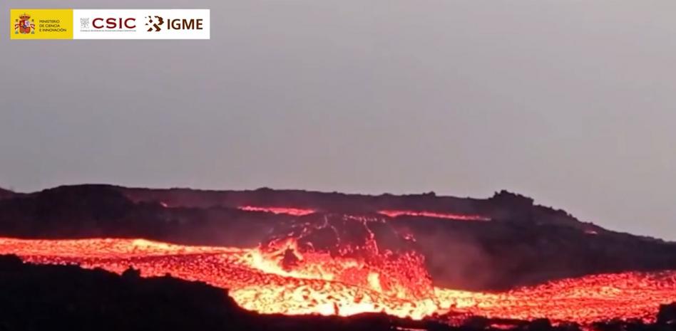 Una geóloga se acerca a un gran bloque de lava descendiendo por una colada en La Palma