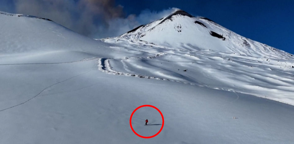 Un esquiador desciende el Etna mientras el volcán entra en erupción