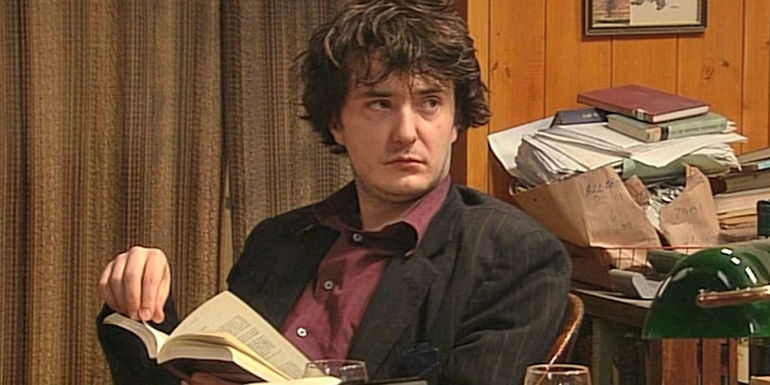 Bernard reading a book in Black Books