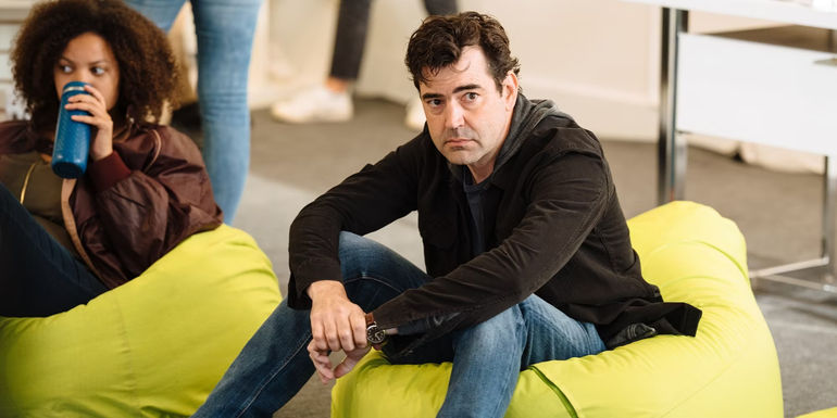 Ron Livingston sitting on a bean bag in Loudermilk