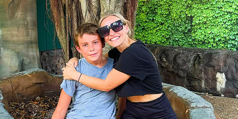 Teen Mom star MacKenzie McKee smiling and wearing sunglasses while hugging her son Gannon