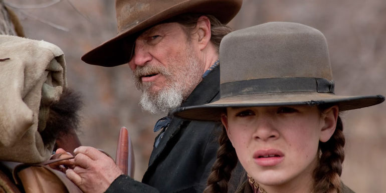 Deputy U.S. Marshal Rooster Cogburn (Jeff Bridges) and Mattie (Hailee Steinfeld) by a horse in True Grit