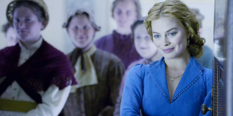 Margot Robbie as Jane smiling and standing in front of villagers in The Legend of Tarzan