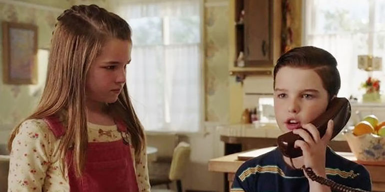 Sheldon on the phone with Missy looking on in Young Sheldon.