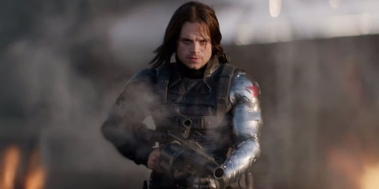 The Winter Soldier holds a smoking grenade launcher as he advances on Captain America and Black Widow in Captain America: The Winter Soldier