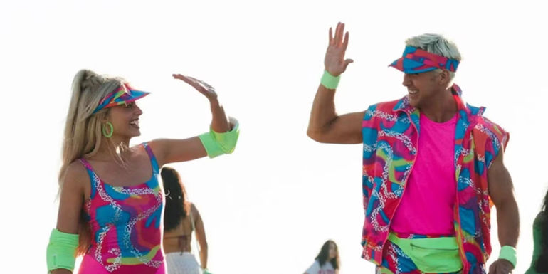 Barbie (Margot Robbie) and Ken (Ryan Gosling) highfiving each other in their rollerblade outfits in Barbie.