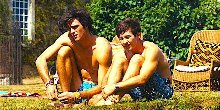 Jacob Elordi and Barry Keoghan sitting together in the grass in Saltburn