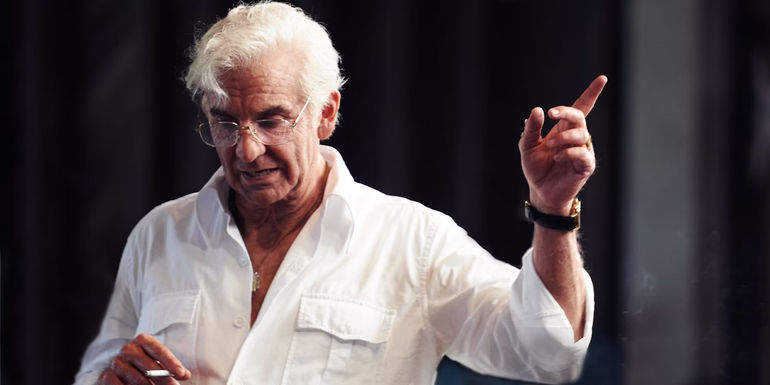 Bradley Cooper as Leonard Bernstein holding a cigarette in Maestro