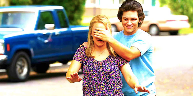 Montana Jordan's Georgie leads Emily Osment's Mandy with his hand over her eyes outside in Young Sheldon