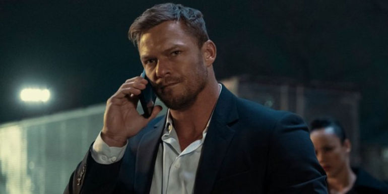 Alan Ritchson speaking on the phone as Reacher