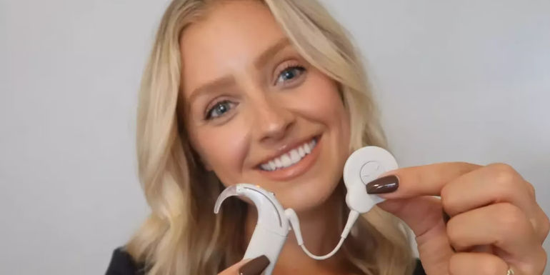 Daisy Kent from The Bachelor Season 28 Holding A Cochlear Implant