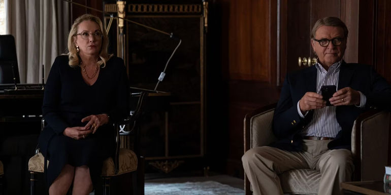 Gerri (J. Smith-Cameron) and Karl (David Rasche) sitting in chairs looking concerned in Succession season 4 episode 4 Honeymoon States.