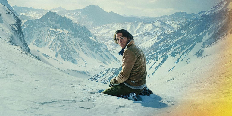 Enzo Vogrincic as Numa kneeling on a snowy mountain in Society of the Snow