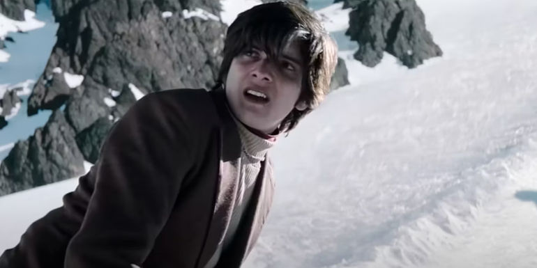 Netflix's Society Of The Snow character looking frightened on a mountain side