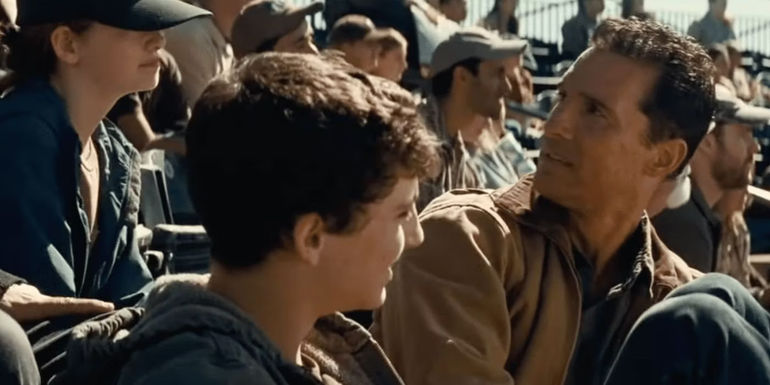 Murphy, Tom and Cooper in the stands at a baseball game in Interstellar