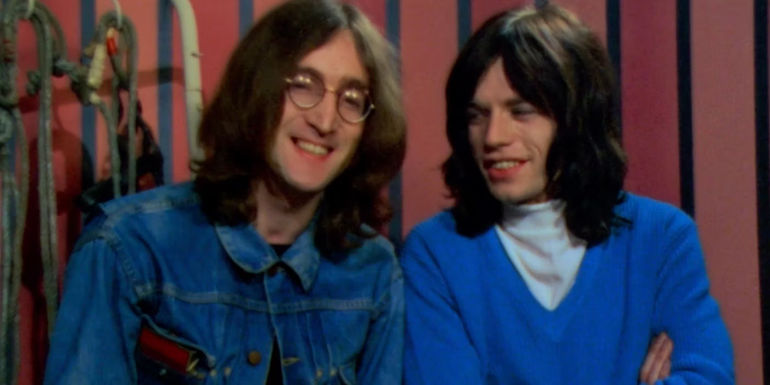 John Lennon and Mick Jagger sitting next to one another in the trailer for The Rolling Stones Rock and Roll Circus