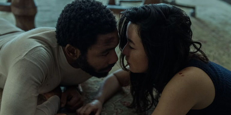 Donald Glover and Maya Erskine face to face on the ground in Mr. & Mrs. Smith tv series