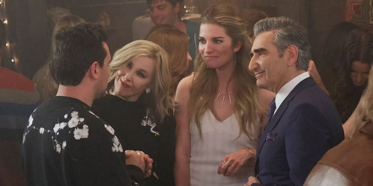 The Rose family talking together at a party in Schitt's Creek