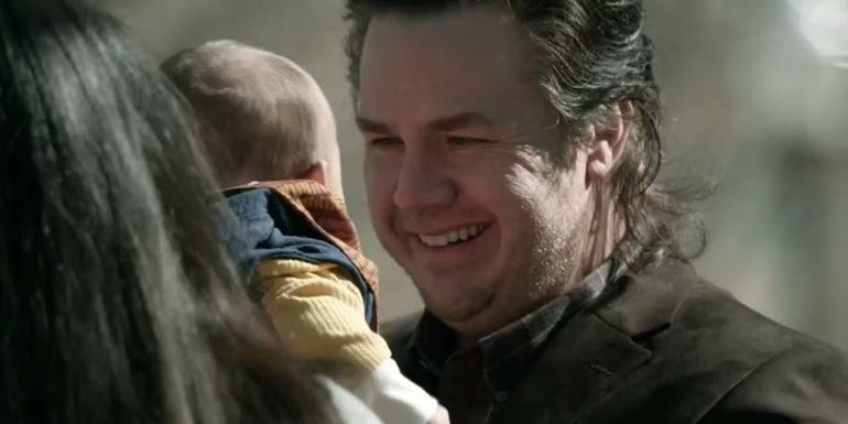 Eugene holding his baby and smiling on The Walking Dead