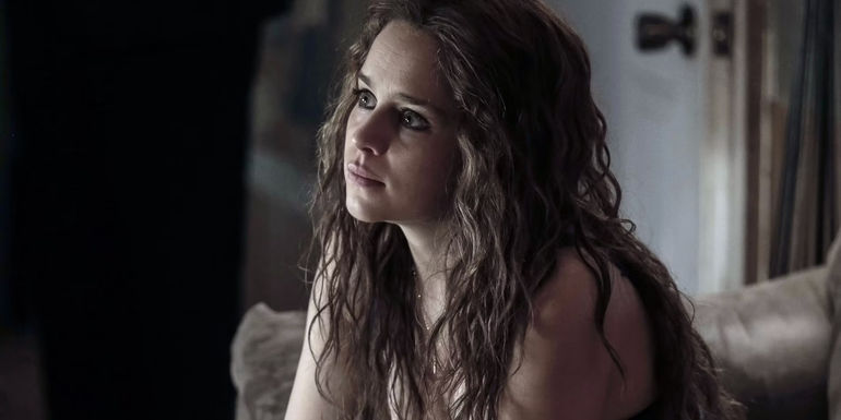 Emilia Clarke as Susan Smith sitting on a sofa in Above Suspicion