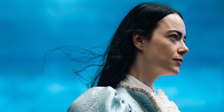 A profile shot of Emma Stone in a blue dress as Bella in Poor Things 