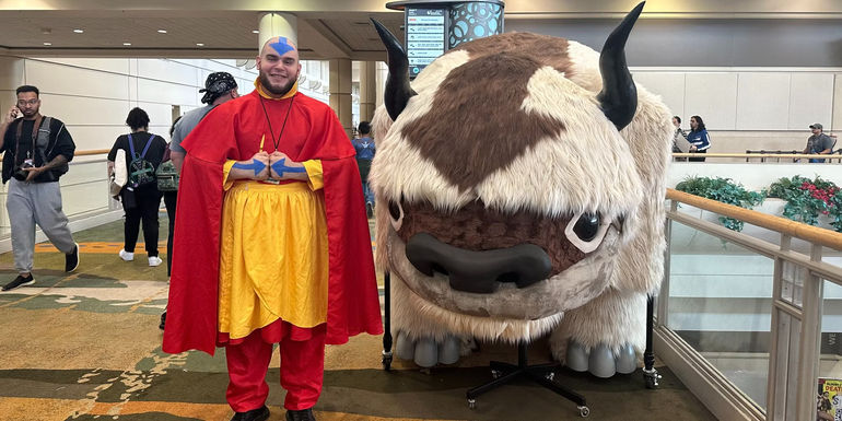 Aang cosplayer standing with Allison Chase's Appa costume as Megacon