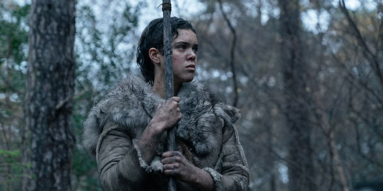 Safia Oakley-Green in the woods holding a spear and looking grave in Out of Darkness