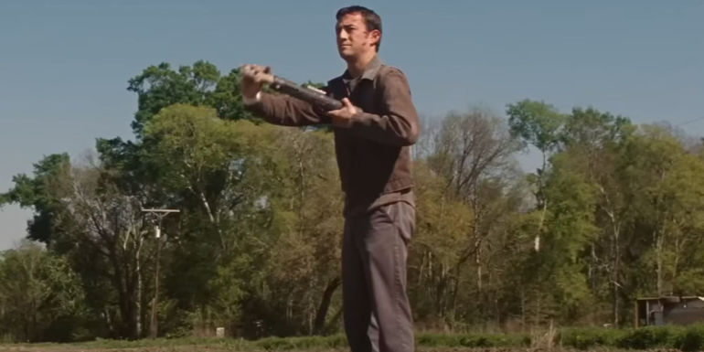 Jason Gordon-Levitt as Young Joe in Looper holding a gun to his chest