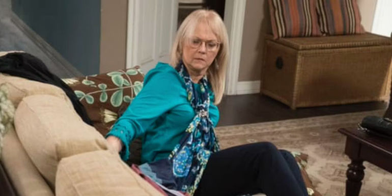 DeDe sitting on the couch on Modern Family