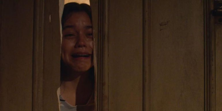 Jenna Ortega as Lorraine Day cries through a broken door in a scene from X.