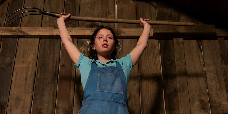 Pearl holding up a pitchfork in Pearl.