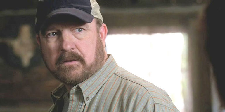 Bobby Singer standing in a room in Supernatural.