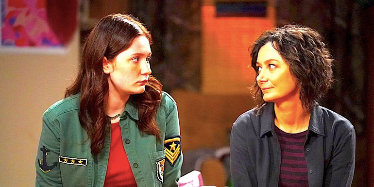 Emma Kenney's Harris and Sara Gilbert's Darlene sit on a bed together talking in The Conners season 2