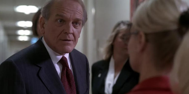 John Spencer as Leo McGarry in a scene from The West Wing, standing and talking to a woman out of view.