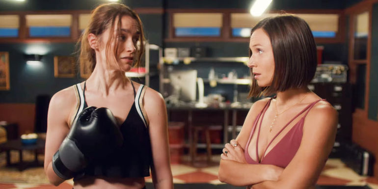 Wynonna standing with boxing gloves next Waverly Earp who has her arms crossed