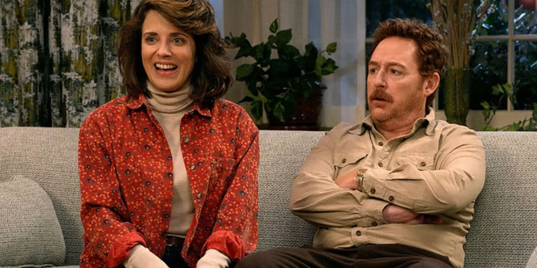 Alanna Ubach as Susan Bennett smiling in Ted as she sits next to Scott Grimes as Matty Bennett