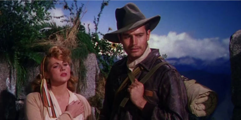 Charlton Heston's Harry Steele stands in a jungle with a woman in Secret of the Incas 1954