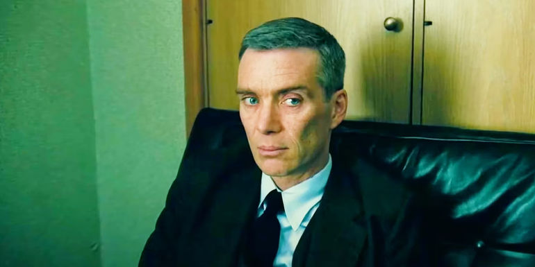 Cillian Murphy's Oppenheimer sitting in a leather chair during a hearing in Oppenheimer.