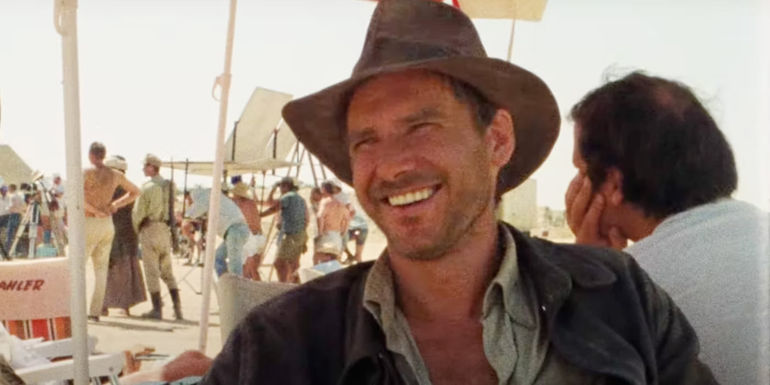 Harrison Ford smiling as Indiana Jones on the set of Raiders of the Lost Ark.