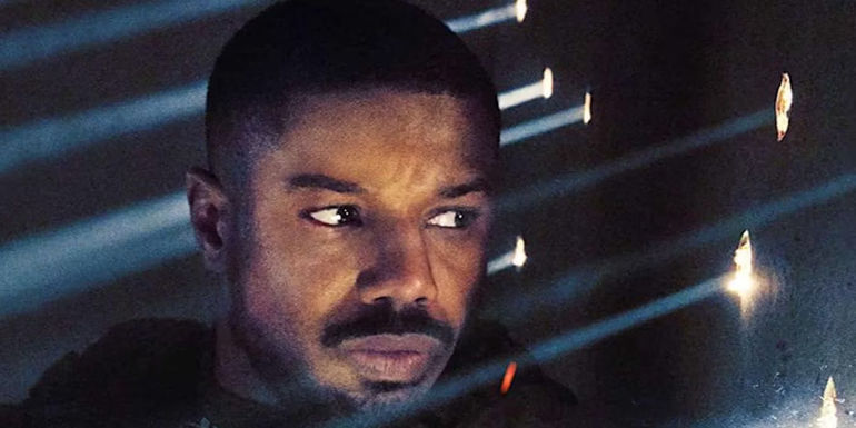 Michael B. Jordan as John Kelly peers through bullet holes in Without Remorse.