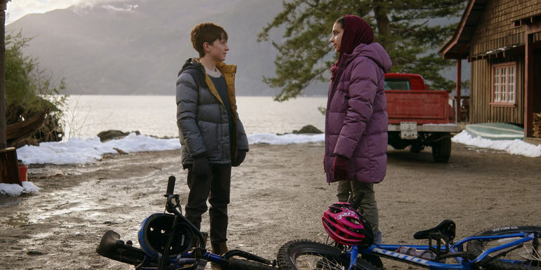 Judah Prehn as Max Hawthorne looking at Gracelyn Awad Rinke as Sahar in Resident Alien season 3.