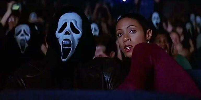 Maureen (Jada Pinkett Smith) sits next to Ghostface in a crowded movie theatre in Scream 2