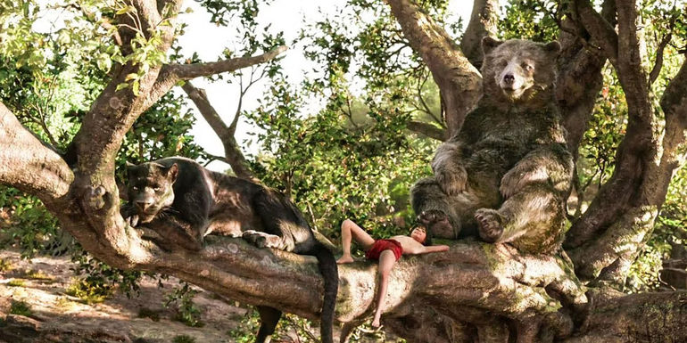 Mowgli (Neel Sethi) laying in a tree with Bagheera (Ben Kingsley) and Baloo (Bill Murray) in The Jungle Book.